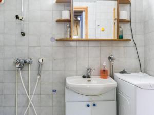a bathroom with a sink and a washing machine at Holiday Home Luppokero 2 by Interhome in Pyhätunturi +4 photos