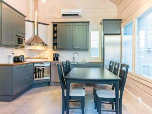 uma cozinha com uma mesa preta e cadeiras em Holiday Home Otso by Interhome em Pyhätunturi