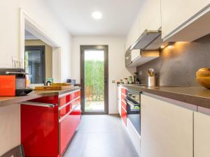 a kitchen with red and white cabinets and a door at Holiday Home La Barca by Interhome in Cambrils