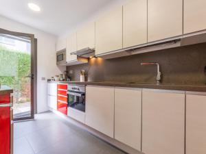 a kitchen with white cabinets and red appliances at Holiday Home La Barca by Interhome in Cambrils +17 photos