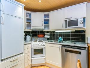 a kitchen with white appliances and a wooden ceiling at Holiday Home Antura b by Interhome in Pyhätunturi