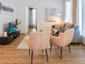 ein Wohnzimmer mit zwei Stühlen und einer Couch in der Unterkunft Holiday Home Hovikatti by Interhome in Vuokatti