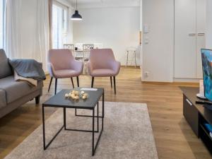 ein Wohnzimmer mit einer Couch und zwei Stühlen und einem Tisch in der Unterkunft Holiday Home Hovikatti by Interhome in Vuokatti