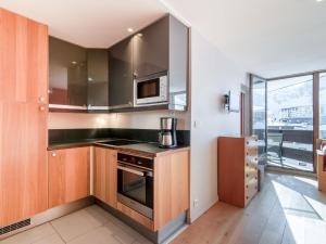 a kitchen with a stove and a microwave at Apartment Les Roches Rouges - Lavachet by Interhome in Tignes