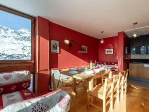 ein Esszimmer mit einem Tisch und einer roten Wand in der Unterkunft Apartment Les Roches Rouges by Interhome in Tignes