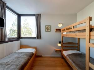 a bedroom with two bunk beds and a ladder at Apartment Les Roches Rouges - Lavachet by Interhome in Tignes