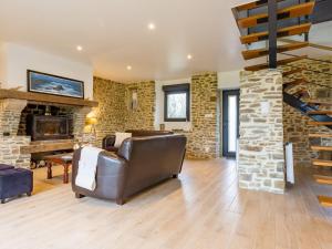 un soggiorno con divano e camino in pietra di Holiday Home La Longére by Interhome a Surville