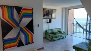 una sala de estar con una pintura en la pared y una silla en Edif. el peñon espectacular vista, en Santa Marta