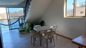 a table and chairs in a room with a balcony at Edif. el peñon espectacular vista in Santa Marta