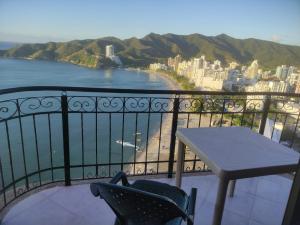 a balcony with a table and chairs overlooking the water at Edif. el peñon espectacular vista in Santa Marta