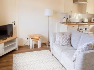 a living room with a couch and a table at Apartment Flat 2 Keeper's Cottage by Interhome in Stenscholl