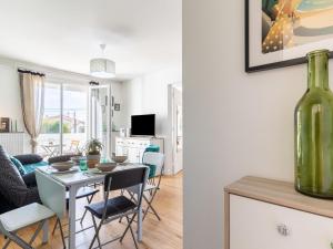 jadalnia i salon ze stołem i wazonem w obiekcie Apartment Coutant-2 by Interhome w mieście Royan