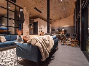ein Wohnzimmer mit einem blauen Sofa und einer Decke darauf in der Unterkunft Holiday Home Villa uggo 4 skipasses included 2024-25 by Interhome in Hyrynsalmi