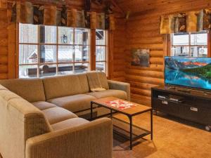 a living room with a couch and a flat screen tv at Holiday Home Kirnutie 3 by Interhome in Pyhätunturi