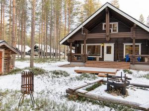 uma cabana de madeira na floresta na neve em Holiday Home Kirnutie 3 by Interhome em Pyhätunturi