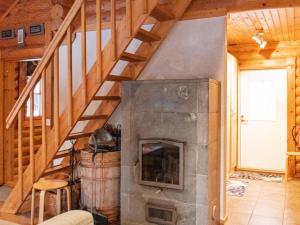 a living room with a fireplace and wooden stairs at Holiday Home Kirnutie 3 by Interhome in Pyhätunturi
