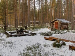 uma cabana de madeira na neve numa floresta em Holiday Home Kirnutie 3 by Interhome em Pyhätunturi