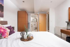a bedroom with a white bed with a tray on it at 22 Zinc in Newquay
