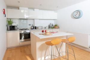 a kitchen with a counter and two bar stools at 22 Zinc in Newquay
