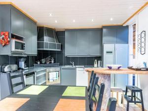 a kitchen with gray cabinets and a wooden table at Holiday Home Pyhän kivi by Interhome in Pyhätunturi