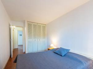 a bedroom with a bed with a blue bedspread at Apartment Le Palazzo del Mar-12 by Interhome in Cavalaire-sur-Mer +15 photos