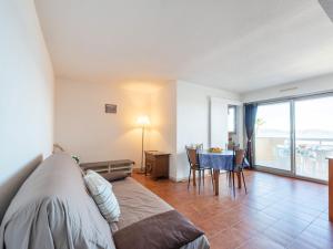 a bedroom with a bed and a table with chairs at Apartment Le Palazzo del Mar-12 by Interhome in Cavalaire-sur-Mer