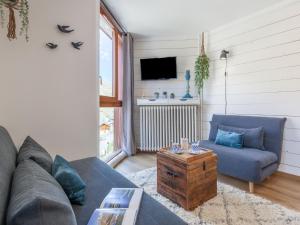 sala de estar con sofá azul y mesa en Apartment Savoy by Interhome, en Tignes