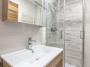 y baño blanco con lavabo y ducha. en Apartment Savoy by Interhome, en Tignes