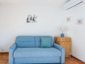 a blue couch in a living room with a lamp at Studio L'Alicastre by Interhome in Le Lavandou