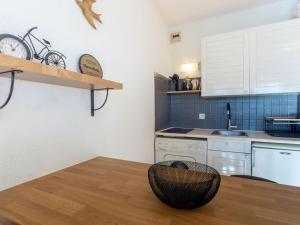 a kitchen with a wooden table and a chair at Studio L'Alicastre by Interhome in Le Lavandou