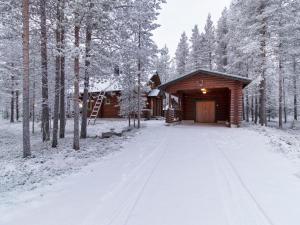 a cabin in the woods with snow on the ground at Holiday Home Petsankolo by Interhome in Pyhätunturi