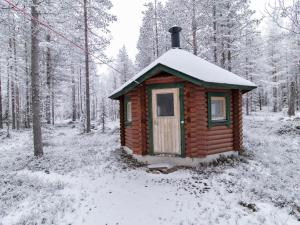 a small wooden cabin in a snow covered forest at Holiday Home Petsankolo by Interhome in Pyhätunturi