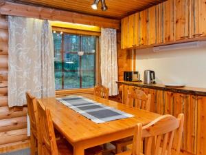 een eetkamer met een houten tafel en een keuken bij Holiday Home Antura a by Interhome in Pyhätunturi