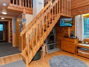 ein Wohnzimmer mit einer Holztreppe und einem TV in der Unterkunft Holiday Home Antura a by Interhome in Pyhätunturi