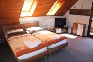 a bedroom with a large bed and a flat screen tv at Apartmány Břestek in Břestek