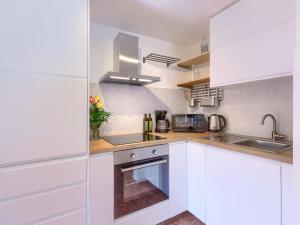 eine Küche mit weißen Schränken und einem Waschbecken in der Unterkunft Holiday Home Casa Negri by Interhome in Labin