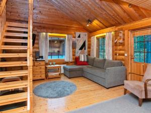 ein Wohnzimmer mit einem Sofa und einer Treppe in einer Hütte in der Unterkunft Holiday Home Antura a by Interhome in Pyhätunturi