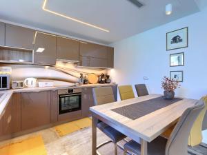 a kitchen and dining room with a wooden table and chairs at Holiday Home Villa Pura Vida by Interhome in Savudrija