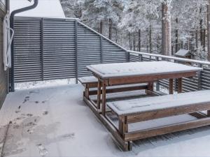 uma mesa de piquenique e bancos cobertos de neve em Holiday Home Pyhänkarhu 3 by Interhome em Pyhätunturi