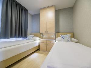 een hotelkamer met 2 bedden en een raam bij Holiday Home Seaside mobile home by Interhome in Šilo