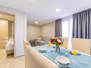 een eetkamer met een blauwe tafel met bloemen erop bij Holiday Home Seaside mobile home by Interhome in Šilo
