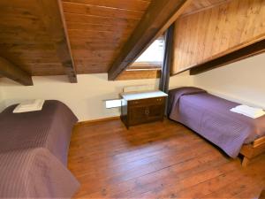 1 dormitorio en el ático con 2 camas y escritorio en Studio Albergo Diffuso - Cjasa de Pagnocca-5 by Interhome, en Barcis