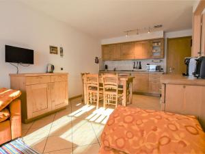 a kitchen with wooden cabinets and a table and chairs at Apartment Cà Serena by Interhome in Campodolcino +23 photos