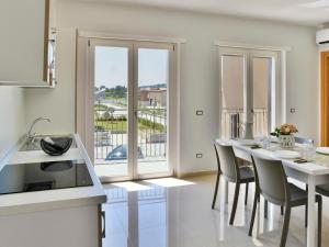 eine Küche mit einem Tisch mit Stühlen und einem großen Fenster in der Unterkunft Apartment Hyele Accomodation Experience-4 by Interhome in Marina di Casalvelino