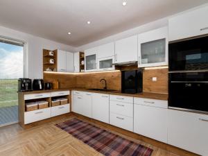 a kitchen with white cabinets and a large window at Holiday Home Emily by Interhome in Csisztapuszta