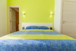 een groot bed met blauwe en gele lakens in een slaapkamer bij Panacea in Salerno