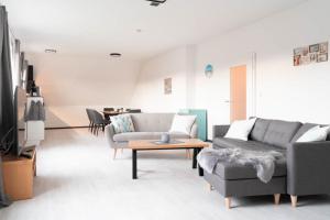 a living room with a couch and a table at Ferienwohnung 140 qm OstfrieslandNordsee für 1-6 Personen - Südbrookmerland in Südbrookmerland