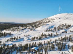 une montagne enneigée avec des arbres et une piste de ski dans l'établissement Holiday Home Villa arcus b includes 2 lift 2024-2025 by Interhome, à Pyhätunturi