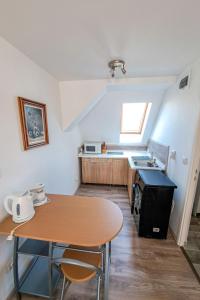 uma pequena cozinha com uma mesa e um lavatório em Apartment Meretei Porta by Interhome em Balatonkeresztúr