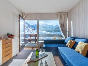 salon z niebieską kanapą i stołem w obiekcie Studio Les Pistes - Lavachet-4 by Interhome w mieście Tignes